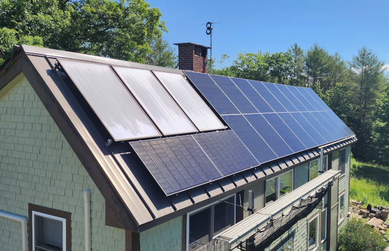 Residential installers install large solar panels onto the roof